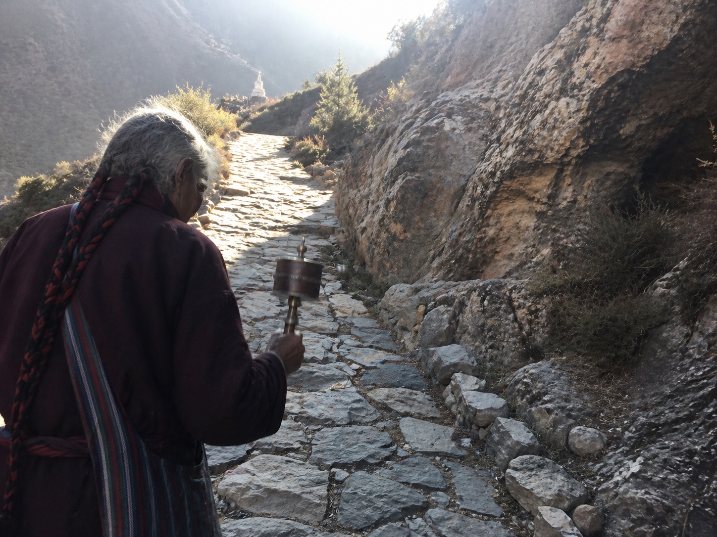 扎耶巴寺轉山步道上的藏族朝聖者手持轉經輪緩行，西藏隱修聖地朝拜路線與實際攀登體驗。